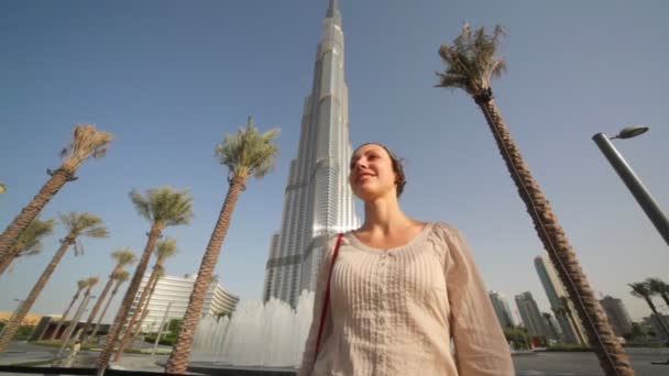 Γυναίκα μπροστά από πηγές κοντά σε Μπουρτζ Ντουμπάι ξενοδοχείο στο Ντουμπάι, Ηνωμένα Αραβικά Εμιράτα — Αρχείο Βίντεο