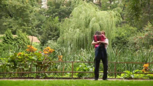 Pareja abrazando y girando alrededor en el jardín — Vídeo de stock