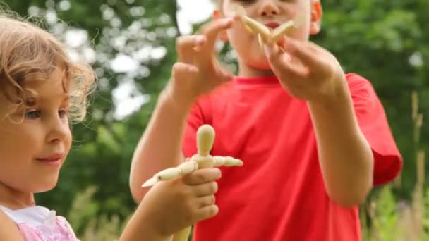 Bror och en syster leker med dockor — Stockvideo