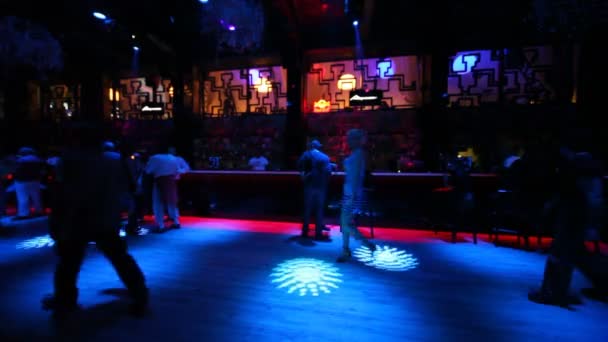 Alcuni si siedono e si rilassano al bar in un nightclub buio con una bella illuminazione — Video Stock