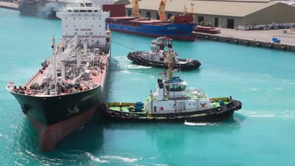 Twee trekkende boten roteert tanker in zeehaven — Stockvideo