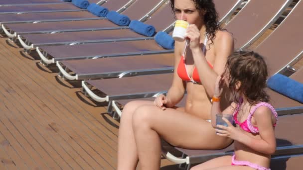 Woman and girl sits on deckchairs on deck of cruise ship — Stock Video