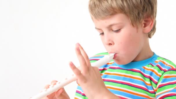Портрет мальчика играет на деревянной трубе — стоковое видео