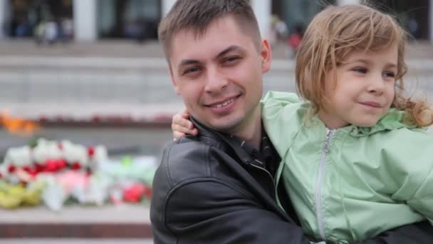 Отец держит дочь на руках против вечного огня в Москве — стоковое видео