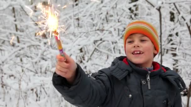 Little boy with firework in snow forest — Stock Video