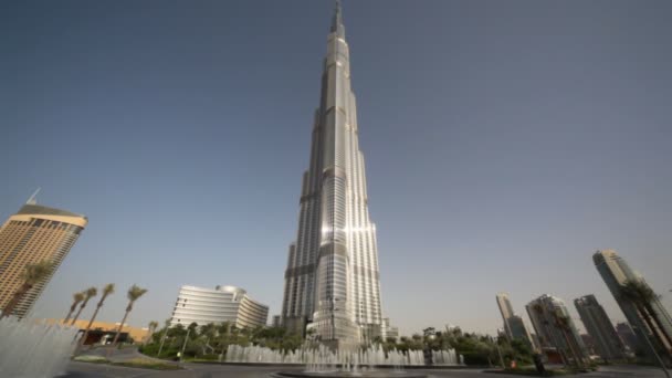 É um dia calmo de verão, em frente ao Burj Dubai e alguns outros edifícios há fontes — Vídeo de Stock