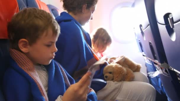 Familie sitzt in Scheibe eingewickelt an Bord des Flugzeugs — Stockvideo