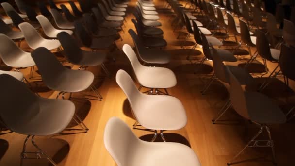 La vista se mueve de muchos a una silla vacía en una oscura sala de conferencias — Vídeo de stock