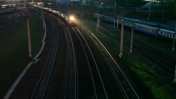 Comboio elétrico subúrbio em movimento na ferrovia noturna perto da estação — Vídeo de Stock