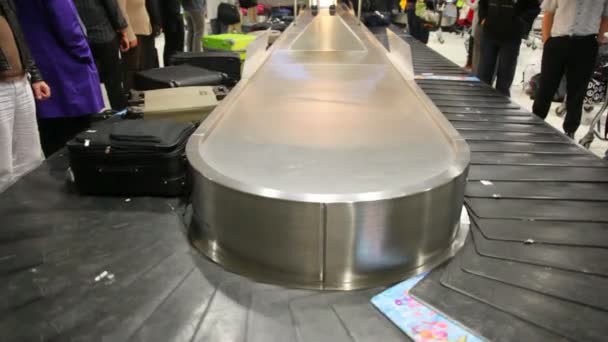 Staan in de luchthaven van bagage gordel te wachten voor bagage — Stockvideo