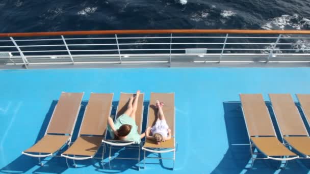 Woman and girl are lying on the deck chairs — Stock Video