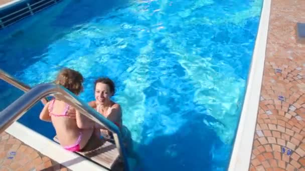 Woman and girl having fun in swimming pool — Stock Video