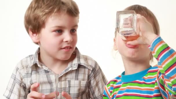 Niño y niña beben jugo — Vídeos de Stock