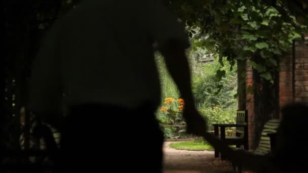 Vue de face sur parents heureux avec enfant courir dans le tunnel de la plante — Video