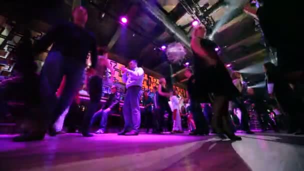 Vue de face sur la piste de danse avec des hommes et des femmes dans une boîte de nuit — Video