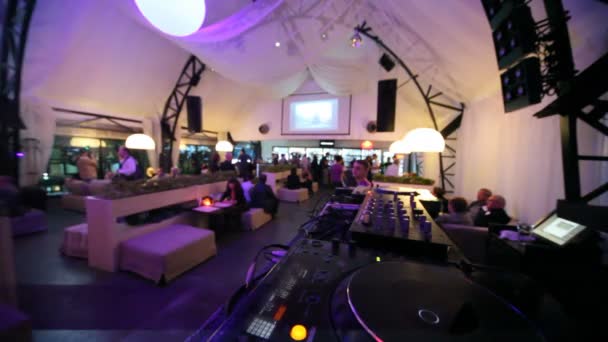 Passeren door dj bedieningspaneel in stijlvol café met verlichting — Stockvideo