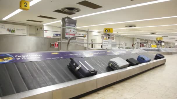 Flytte bagasjebelg med bagasje på flyplassen i London, Storbritannia . – stockvideo