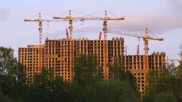 Under konstruktion hus och kranar mot solnedgång himlen i Moskva, Ryssland — Stockvideo