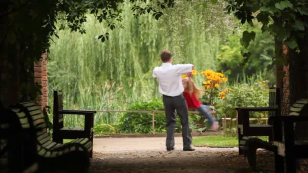 Father holds hands of his daughter and whirling her around — Stock Video