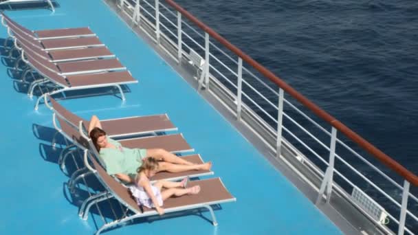 Woman and girl lying on deck chairs — Stock Video