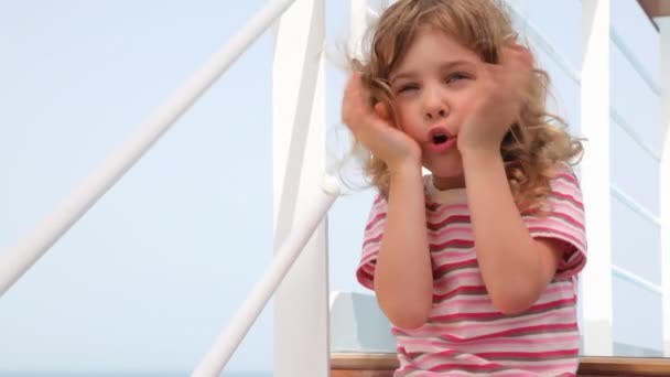 Flickan gör ansikten på däck på fartyg — Stockvideo