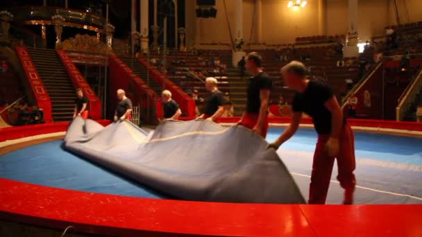 Рабочие закатывают матовую поверхность арены в Старом Никулинском цирке, Москва, Россия — стоковое видео