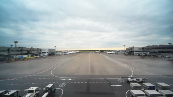 Visão de aeroportos campo com caminhões sobre ele através da janela — Vídeo de Stock