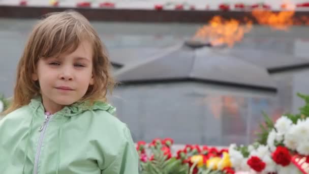 Mädchen steht gegen ewiges Feuer auf Denkmal für unbekannten Soldaten — Stockvideo