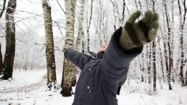 Pojke i snö skog sträcka händerna tittar upp i himlen — Stockvideo