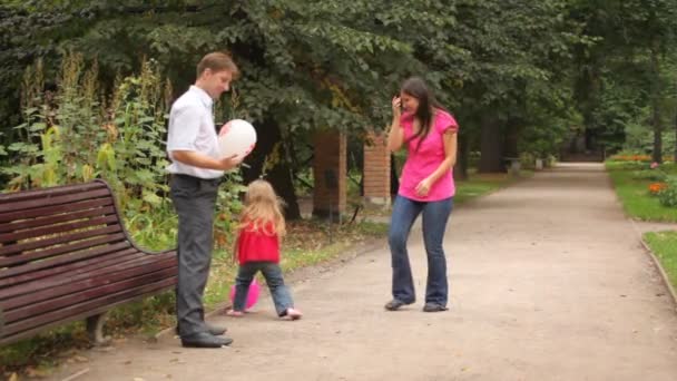 Parents and daughter play some game with balloons — Stock Video