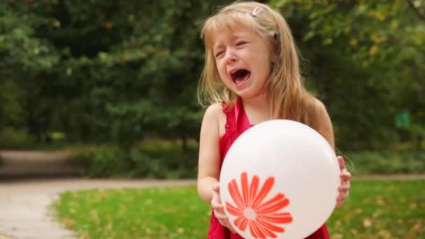 Chica rubia de pie con globo en las manos y llora — Vídeos de Stock