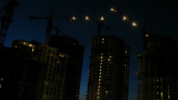 Poste de nuit sur le chantier de construction au premier plan du paysage urbain de la zone dortoir — Video