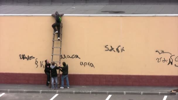Hooligans klim op een dak. — Stockvideo