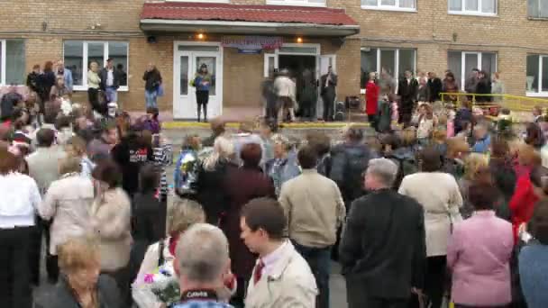 Children and parents enter school after celebrating the start of school year — Stock Video