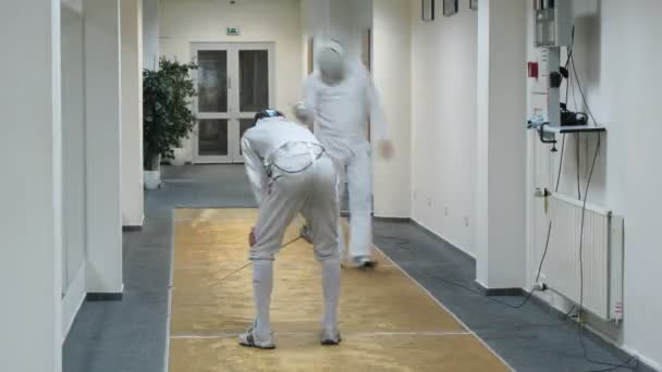 Dos hombres terminan su esgrima en el gimnasio Multisport — Vídeo de stock