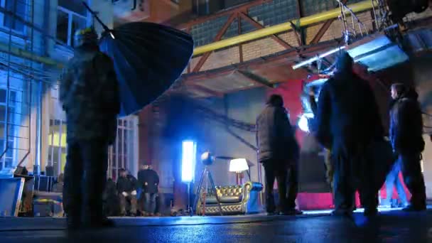 Técnicos de iluminación ajustan el equipo durante la filmación al aire libre — Vídeos de Stock