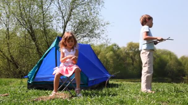 小男孩和女孩在森林的蓝色帐篷附近戏剧在夏季的一天 — 图库视频影像