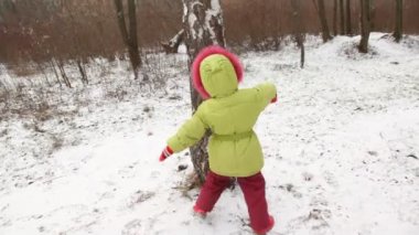 sevimli küçük kız dansları kış ahşap ağaç yuvarlak.