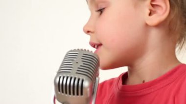 güzel kız beyaz zemin üzerinde mikrofon şarkı söylüyor