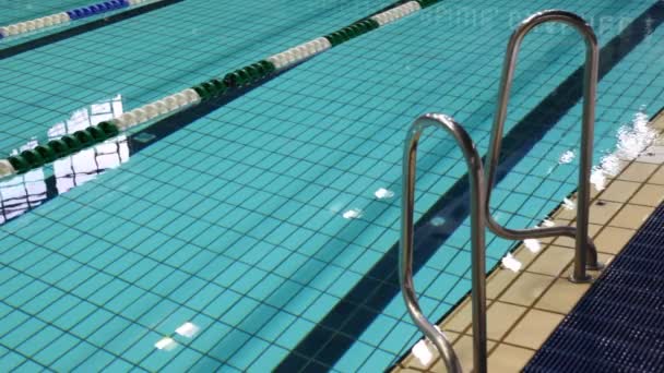 Piscina com água azul, e trilho na sua borda — Vídeo de Stock