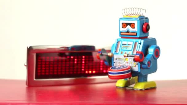 Closeup modré mechanický robot chodí na stole před osvětlovacím panelem s technologií slovo, údery bubnu — Stock video
