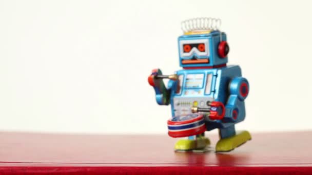 Closeup of blue clockwork robot walks on table, beats drum — Stock Video