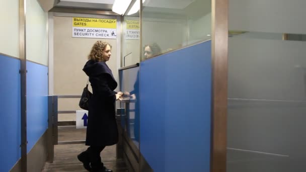 Frau steht am Sicherheitskontrollpunkt am Flughafen — Stockvideo