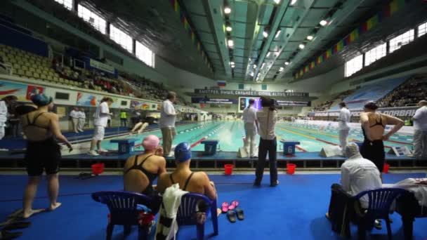 Sportswomen in relay, some finish backstroke, others start breaststroke on open championship — Stock Video