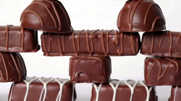 Pirámide de diferentes chocolates sobre fondo blanco — Vídeos de Stock