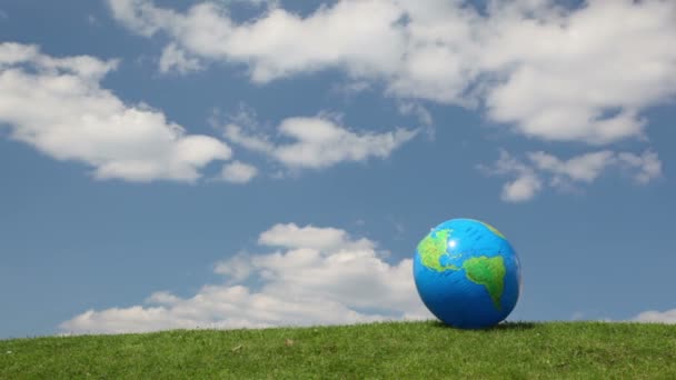 Globe à la recherche boule gonflable dans la prairie — Video