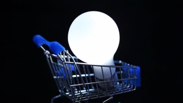 Nahaufnahme einer weißen elektrischen Lampe im Spielzeug-Einkaufswagen — Stockvideo