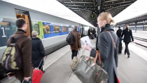 As pessoas na estação estão andando ao longo do trem — Vídeo de Stock