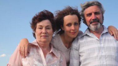 Olgun çift yetişkin kızları gökyüzü yaz aylarında kucaklayan standları