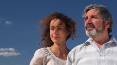 yaşlı adam ve yetişkin bir kızı gökyüzü yaz karşı durmak